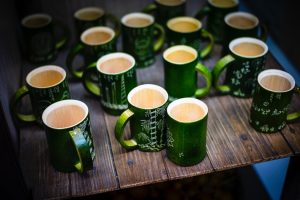 a group of green mugs sitting on top of a wooden table